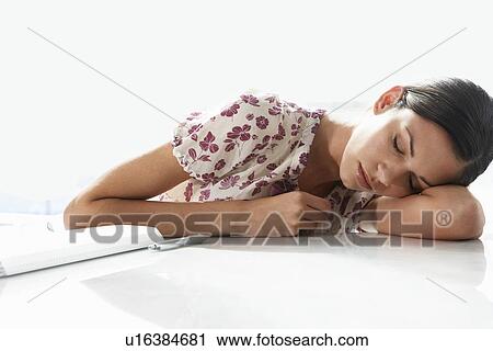 Stock Image - Woman Resting on Desk. Fotosearch