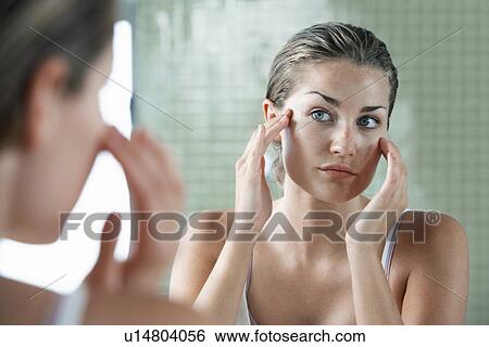 Woman rubbing temples in front of mirror View Large Photo Image Stock Photograph - Woman rubbing temples in front of mirror. Fotosearch