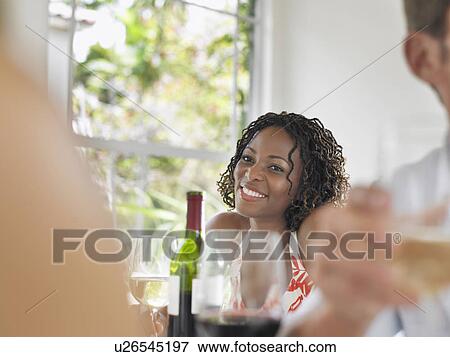 Stock Photo - Woman sitting at table smiling portrait. Fotosearch
