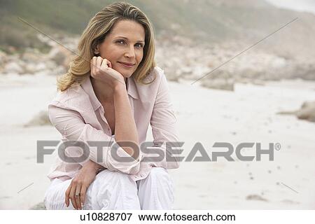 Stock Photo - Woman sitting on beach portrait. Fotosearch