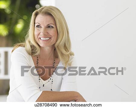 Stock Image - Woman sitting on verandah portrait. Fotosearch