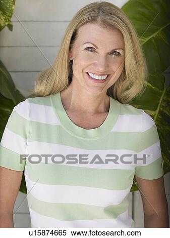 Stock Photography - Woman standing against house wall portrait. Fotosearch
