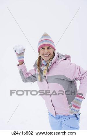 Stock Image - Woman throwing snowball portrait. Fotosearch