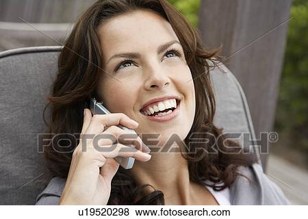 Stock Photo - Woman using cell phone head and shoulders. Fotosearch
