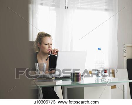 Woman using laptop sitting at office View Large Photo Image Stock Image - Woman using laptop sitting at office. Fotosearch