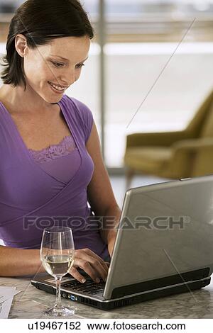 Woman Using Laptop sitting at table half length View Large Photo Image Stock Image - Woman Using Laptop sitting at table half length. Fotosearch