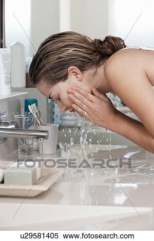 Woman washing face in bathroom View Large Photo Image Stock Photography - Woman washing face in bathroom. Fotosearch