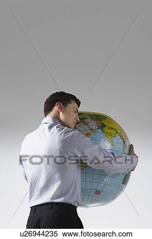 Young adult man with arms around big globe back view View Large Photo Image Stock Photography - Young adult man with arms around big globe back view. Fotosearch