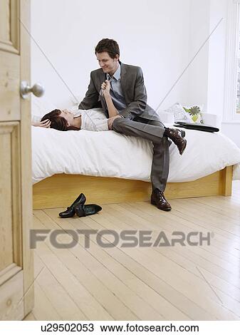 Young businessman and woman relaxing in bedroom View Large Photo Image Stock Image - Young businessman and woman relaxing in bedroom. Fotosearch