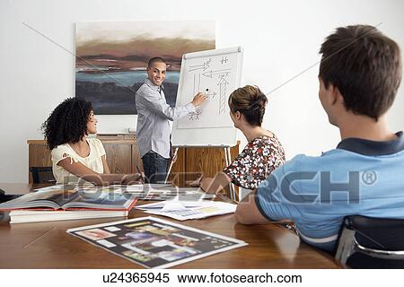 Young Businesspeople watching colleague Giving Presentation in conference room View Large Photo Image Stock Photography - Young Businesspeople watching colleague Giving Presentation in conference room. Fotosearch