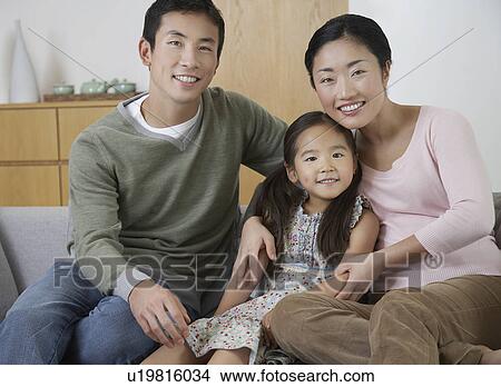 Picture - Young couple and daughter Posing on Sofa. Fotosearch