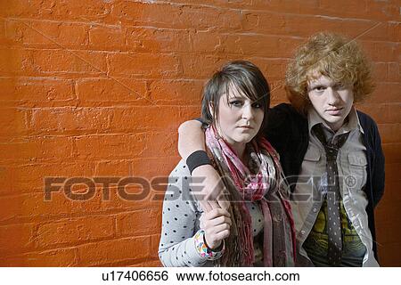 Young couple embracing in front of brick wall View Large Photo Image Stock Photograph - Young couple embracing in front of brick wall. Fotosearch