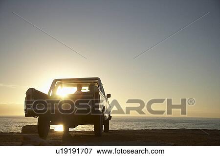 Stock Photo - Young couple in van parked in front of ocean. Fotosearch