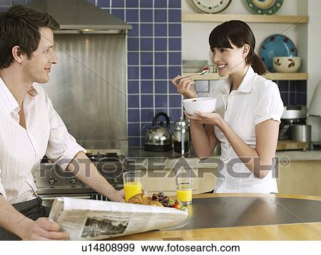 Stock Photo - Young couple relaxing in kitchen. Fotosearch