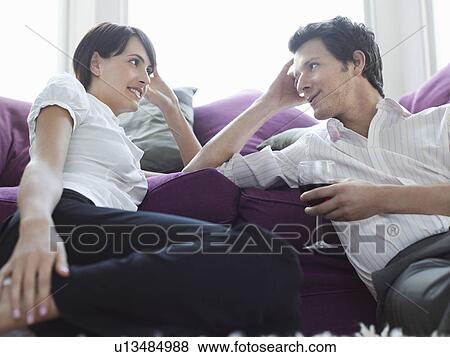 Young couple relaxing on sofa View Large Photo Image Stock Photo - Young couple relaxing on sofa. Fotosearch