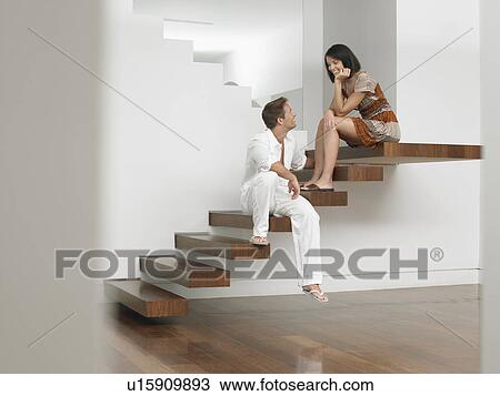 Stock Image - Young Couple Sitting on Stairs. Fotosearch