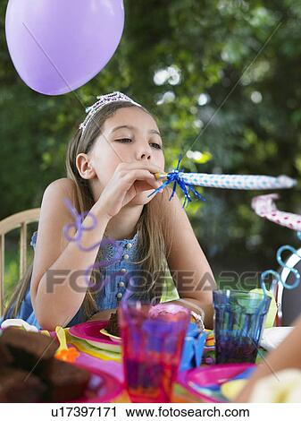 Young girl (10-12) blowing party puffer at birthday party View Large Photo Image Stock Image - Young girl (10-12) blowing party puffer at birthday party. Fotosearch