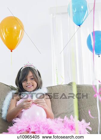 Young girl (7-9) on sofa preparing birthday balloons View Large Photo Image Stock Photography - Young girl (7-9) on sofa preparing birthday balloons. Fotosearch
