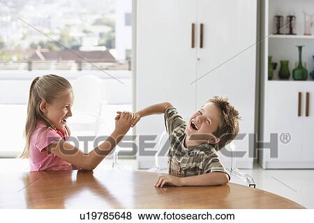 Young girl and boy fighting at table at home View Large Photo Image Stock Photo - Young girl and boy fighting at table at home. Fotosearch