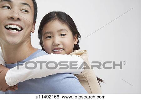 Stock Photograph - Young Girl Getting Piggyback Ride with Father close-up. Fotosearch
