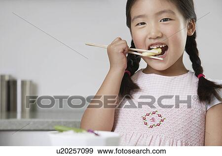 Young Girl with pigtails Eating Baby Corn with chopsticks View Large Photo Image Stock Photo - Young Girl with pigtails Eating Baby Corn with chopsticks. Fotosearch