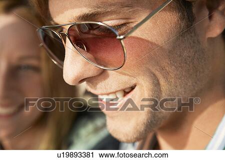 Young man close up young woman in background View Large Photo Image Stock Image - Young man close up young woman in background. Fotosearch