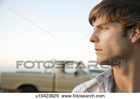 Stock Photo - Young man head and shoulders profile in front of van. Fotosearch