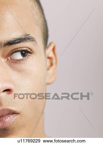 Stock Photo - Young man looking to side close-up of face (cropped). Fotosearch