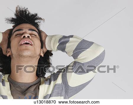Young man pulling hair back View Large Photo Image Stock Image - Young man pulling hair back. Fotosearch