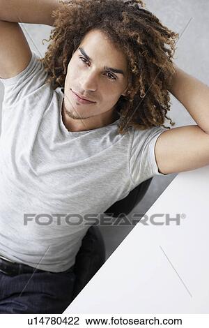 Young man sitting at desk elevated view portrait View Large Photo Image Stock Image - Young man sitting at desk elevated view portrait. Fotosearch