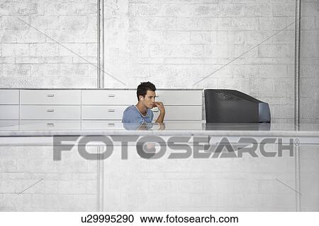 Young man sitting in front of television set wearing earphones View Large Photo Image Stock Image - Young man sitting in front of television set wearing earphones. Fotosearch