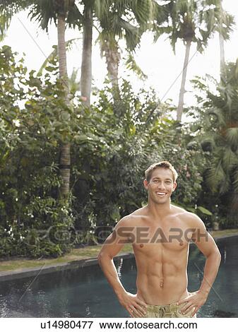 Stock Photo - Young Man Standing at Swimming Pool. Fotosearch