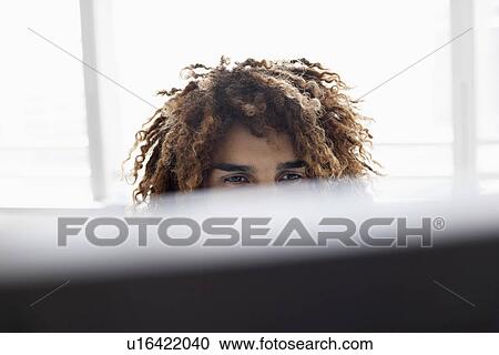 Young man using computer sitting at desk close up View Large Photo Image Stock Image - Young man using computer sitting at desk close up. Fotosearch