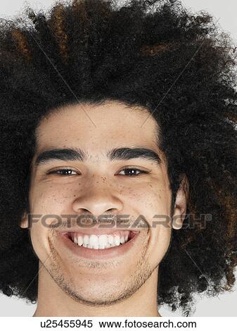 Stock Photography - Young man with afro grinning close-up. Fotosearch