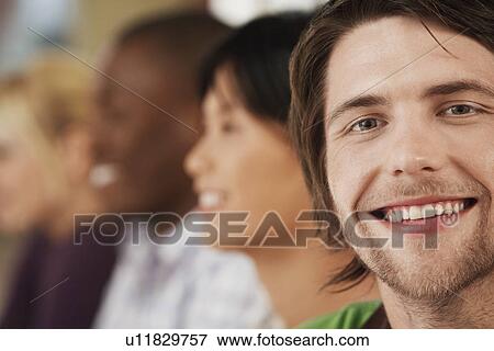 Stock Photo - Young man with three people in background.. Fotosearch