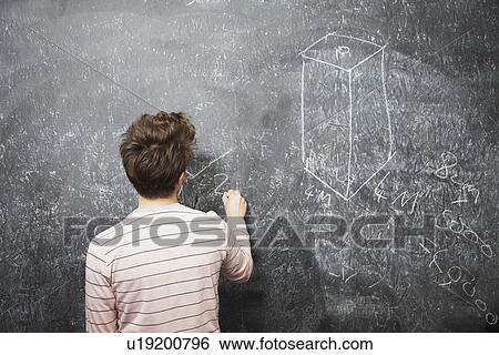 Stock Photograph - Young man writing on blackboard back view. Fotosearch