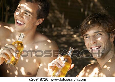 Stock Photograph - Young men drinking beer outside head and shoulders. Fotosearch