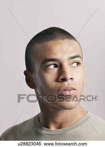 Young pensive man looking away close-up View Large Photo Image Stock Photograph - Young pensive man looking away close-up. Fotosearch