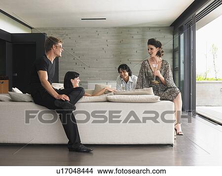 Young people drinking champagne in living room View Large Photo Image Picture - Young people drinking champagne in living room. Fotosearch