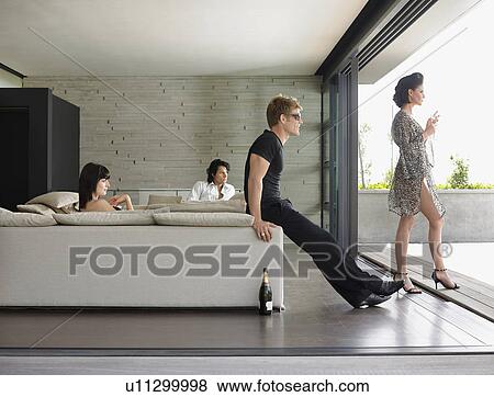 Young people drinking champagne in living room View Large Photo Image Stock Photo - Young people drinking champagne in living room. Fotosearch