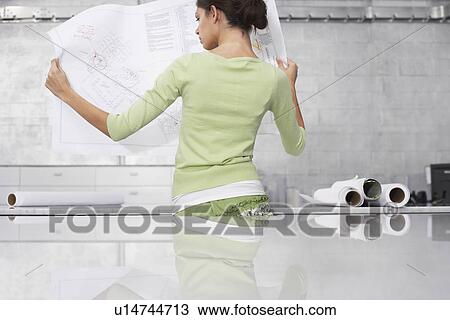 Young woman holding blueprint back view View Large Photo Image Stock Image - Young woman holding blueprint back view. Fotosearch