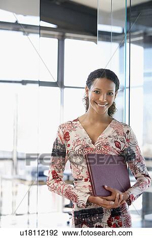 Young woman holding folder in office front view portrait. View Large Photo Image Stock Image - Young woman holding folder in office front view portrait.. Fotosearch