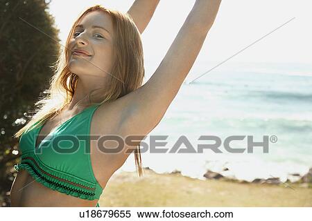 Stock Photography - Young woman in bikini at beach half length. Fotosearch
