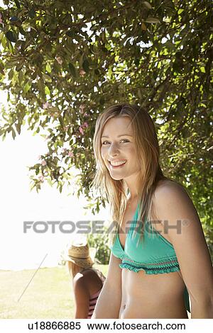 Stock Photography - Young woman in bikini at beach half length. Fotosearch