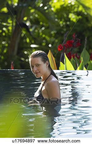 Young woman in natural swimming pool portrait View Large Photo Image Stock Photo - Young woman in natural swimming pool portrait. Fotosearch