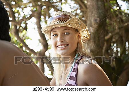 Stock Photo - Young woman in sun hat outdoors head and shoulders. Fotosearch