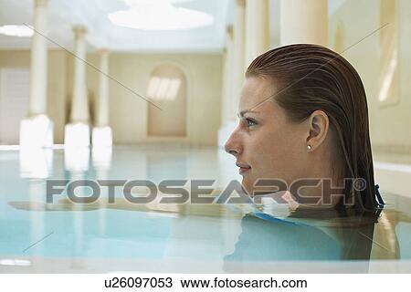 Stock Image - Young woman in swimming pool profile. Fotosearch