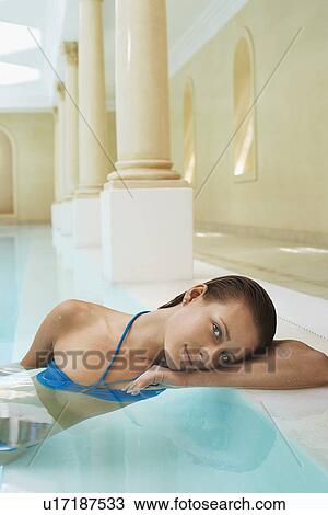 Young woman leaning on edge of swimming pool portrait View Large Photo Image Stock Image - Young woman leaning on edge of swimming pool portrait. Fotosearch