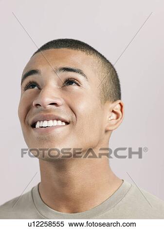 Stock Photography - Young woman looking up and smiling close-up. Fotosearch