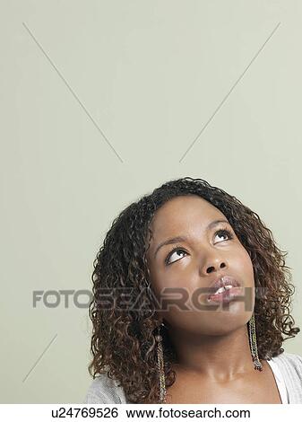 Stock Photograph - Young woman looking up. Fotosearch